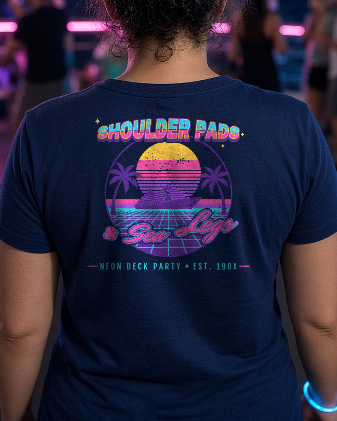 Mockup: navy Shoulder Pads & Sea Legs tee, back print, worn at a neon night deck party