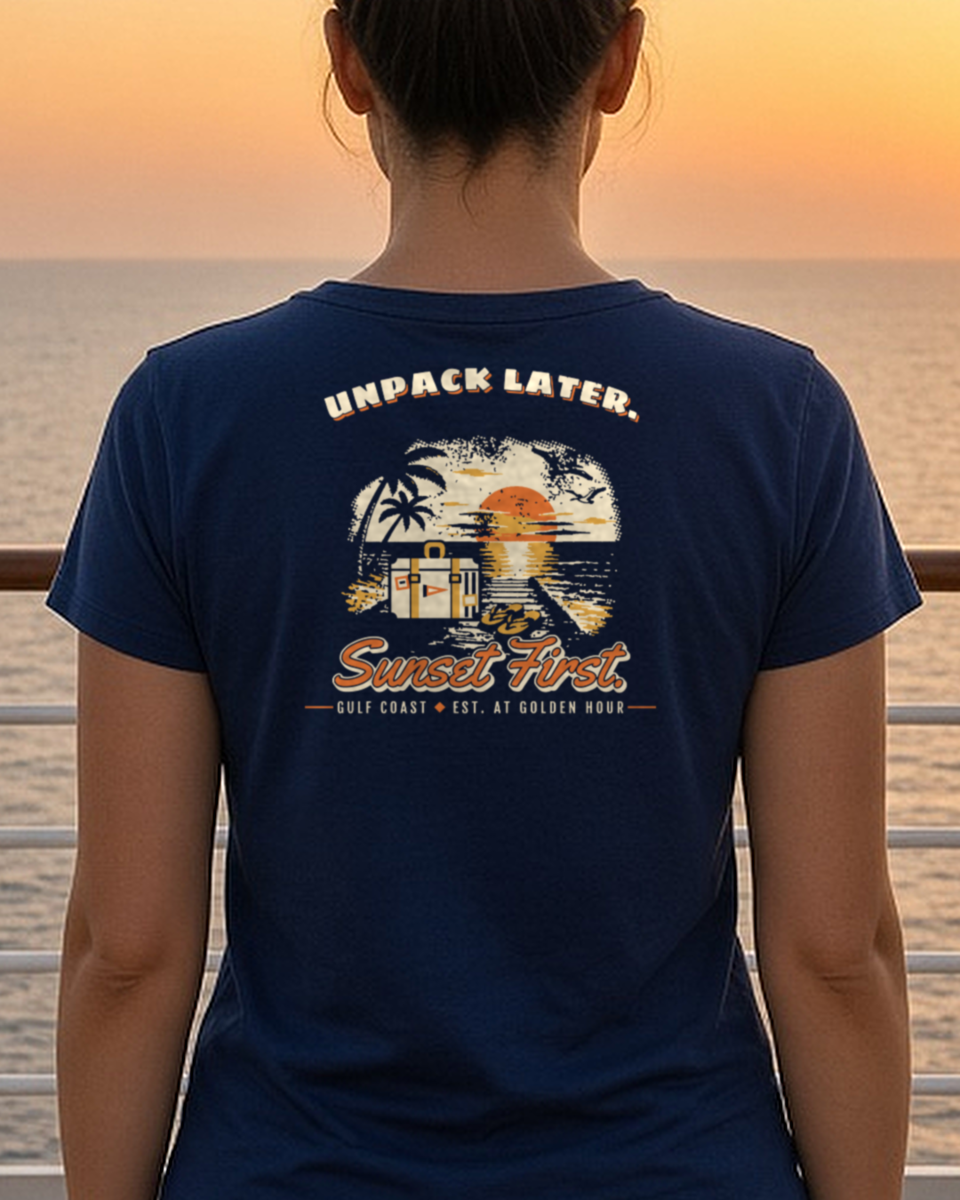 Mockup: navy Unpack Later. Sunset First. tee, back print, worn at a deck rail at golden hour
